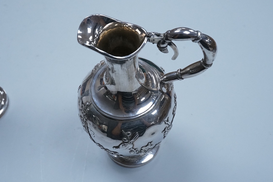 An early 20th century Chinese Export white metal posy vase, by Wang Hing, 18.4cm and a similar ewer by Tien Shing?, lacking cover.